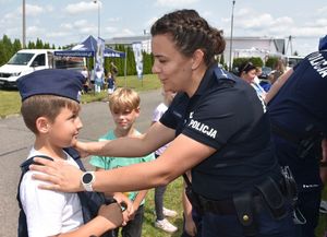 Policjantka zakłada chłopcu element policyjnego umumdurowania