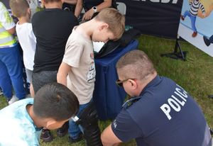 Policjant ubiera dziecko w element policyjnego umundurowania