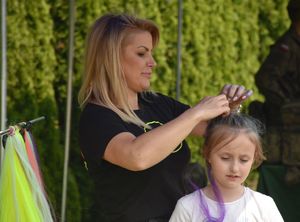 Kobieta robi fryzurę dziewczynce