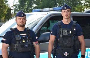 Dwóch policjantów przed radiowozem