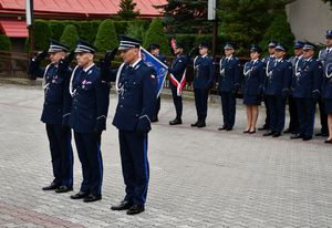 Komendanci oddają honory przed pomnikiem. W tle policjanci