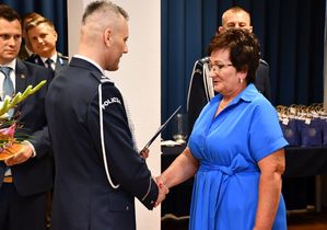 Komendant wręcza list gratulacyjny kobiecie