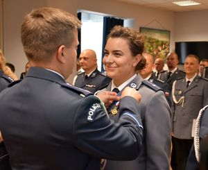Policjant wręcza medal policjantce