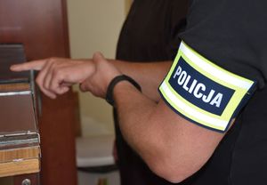 Policjant pobiera od mężczyzny odciski palców