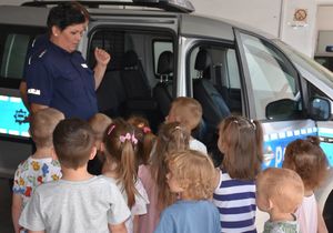 Policjantka  dziećmi przy radiowozie