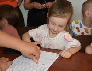 Dziewczynka w trakcie robienia odcisków palców