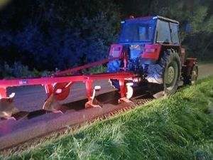 Traktor z pługiem na drodze