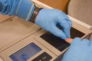 Technik pobiera odciski palców od mężczyzny