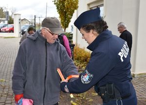 Policjantka daje odblask mężczyźnie