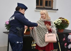 Policjantka zakłada odblask kobiecie