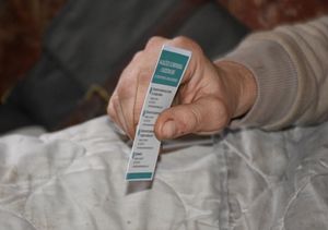 Dłoń. W ręce osoba trzyma ulotkę.