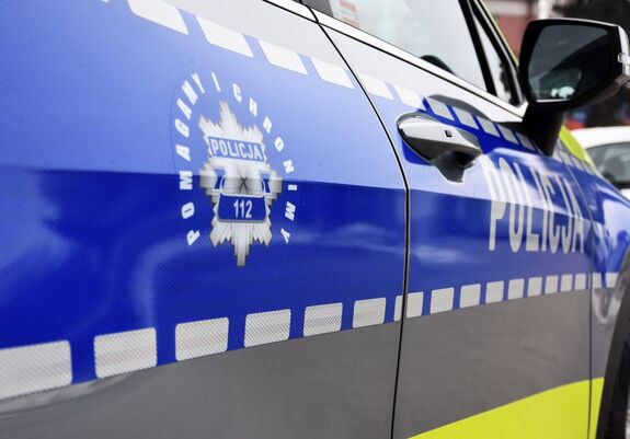 Zdjęcie części radiowozu z policyjną gwiazdą z napisem pomagamy i chronimy