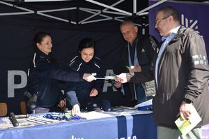 Policjantki na policyjnym stoisku. Przy stoisku stoją także mężczyźni