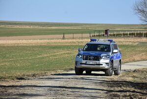 Radiowóz na tle pól ornych