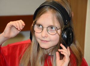 Dziewczynka w okularach i słuchawkach
