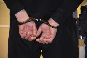 Mężczyzna ma na rękach założone kajdanki
