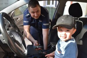 Policjant z małym chłopcem w radiowozie