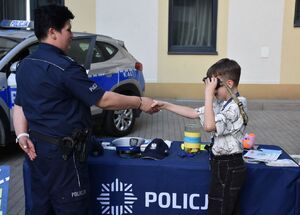Policjantka z chłopcem na policyjnym stoisku
