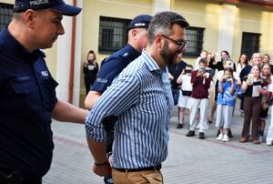 Policjanci doprowadzają osobę zatrzymaną do sądu