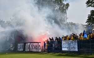 Kibice na stadionie w strefie kibica odpalili race
