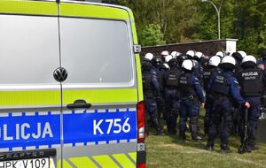 Radiowóz, w tle policjanci zabezpieczają mecz