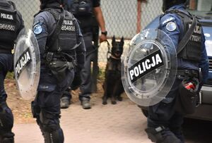 Policjanci z tarczami podczas zabezpieczenia meczu