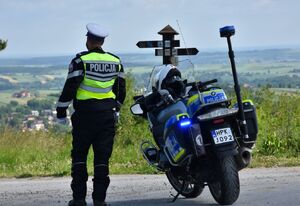 Motocykl. Obok niego policjant