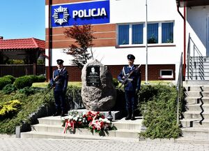 Tablica pamięci obok której znajdują się policjanci