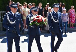 Policjanci maszerują z wiązanką kwiatów
