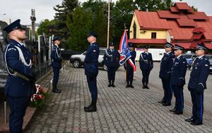 Policjanci składają wiązankę przed pomnikiem
