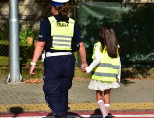 Policjantka przeprowadza dziewczynkę przez przejście dla pieszych