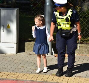 Policjantka  z dziewczynką przed przejściem dla pieszych