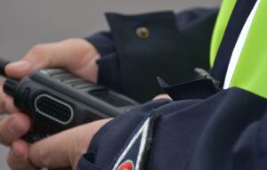 Policjant trzyma w ręce radiostację