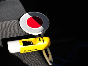 Żółty alkomat i tarcza do zatrzymywania pojazdów leżące na fotelu radiowozu