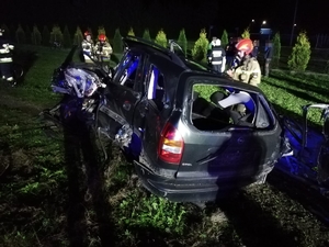 Uszkodzony opel, obok strażacy