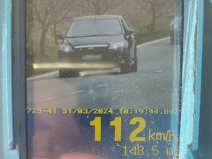 Ekran ręcznego miernika prędkości wyświetlający mierzony pojazd oraz jego prędkość 112 km/h