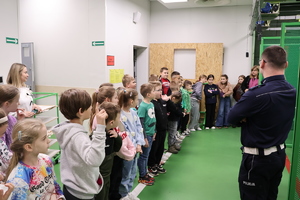 Policjant mówiący do dzieci na strzelnicy