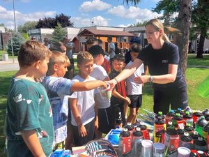 policjantka trzymająca losy z pytaniami i dzieci