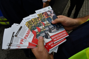 Policjanci z wraz z przedstawicielami komisji rozdający ulotki przed szkołami
