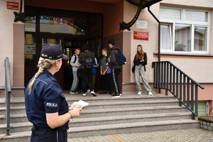 Policjanci z wraz z przedstawicielami komisji rozdający ulotki przed szkołami