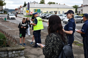 Policjanci z wraz z przedstawicielami komisji rozdający ulotki przed szkołami