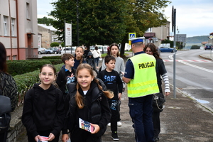 Policjanci z wraz z przedstawicielami komisji rozdający ulotki przed szkołami