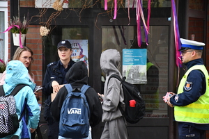 Policjanci z wraz z przedstawicielami komisji rozdający ulotki przed szkołami