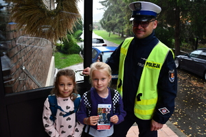 Policjanci z wraz z przedstawicielami komisji rozdający ulotki przed szkołami