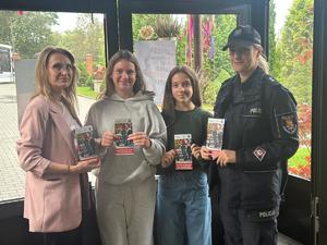 Policjanci z wraz z przedstawicielami komisji rozdający ulotki przed szkołami