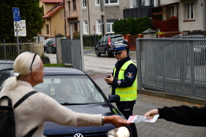 Policjanci z wraz z przedstawicielami komisji rozdający ulotki przed szkołami