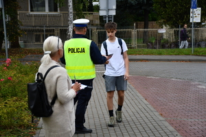 Policjanci z wraz z przedstawicielami komisji rozdający ulotki przed szkołami