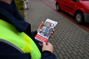 Policjanci z wraz z przedstawicielami komisji rozdający ulotki przed szkołami