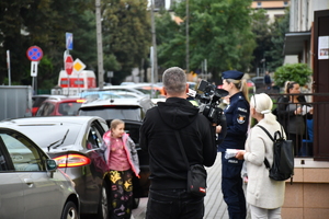 Policjanci z wraz z przedstawicielami komisji rozdający ulotki przed szkołami
