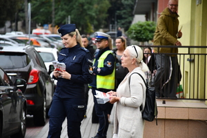 Policjanci z wraz z przedstawicielami komisji rozdający ulotki przed szkołami